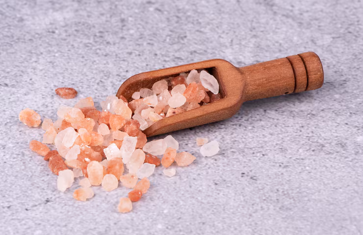 Coarse Himalayan pink salt scooped from a container