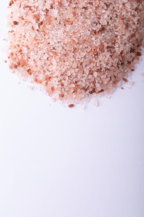 Close-up of Himalayan pink rock salt on a white background