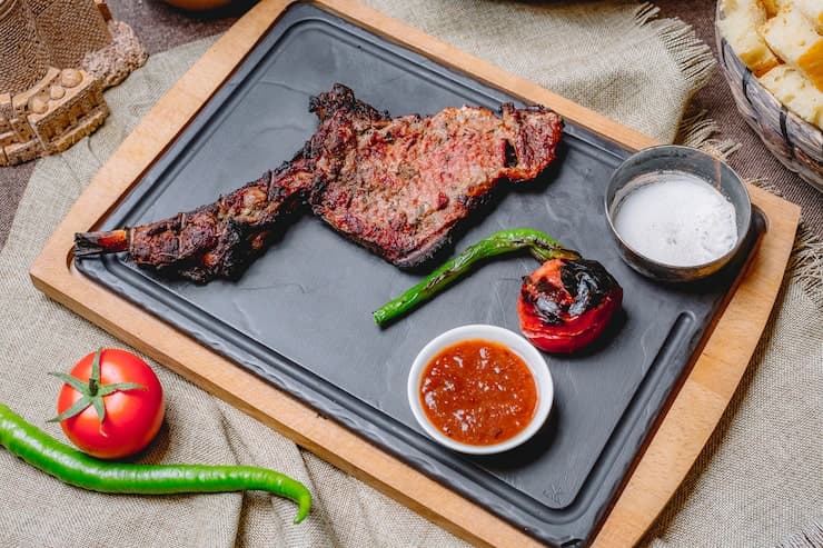 Grilled steak and vegetables served after cooking on a hot surface