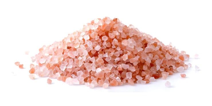 Pile of isolated Himalayan pink salt crystals on white